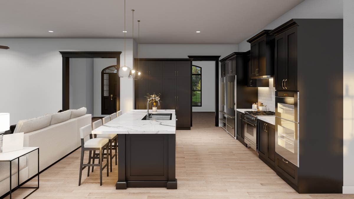 Modern kitchen with dark cabinetry, a large island with waterfall countertop, stainless steel appliances, and an open layout to a living area.