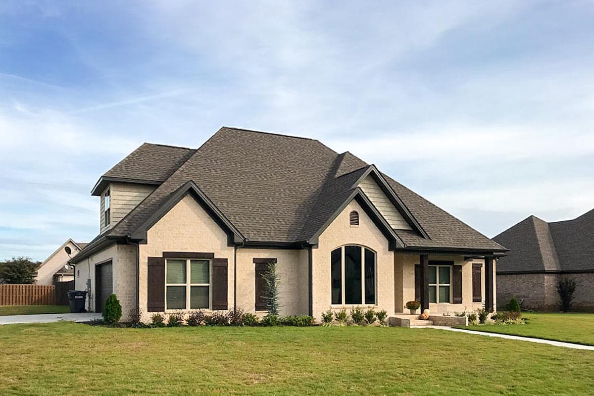 House plan exterior of a two-story Modern Farmhouse with brick facade, gable roof, dormers, and attached garage.