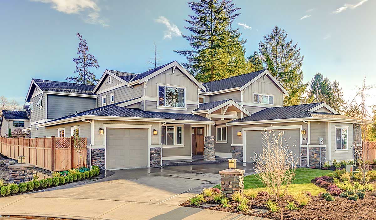 House plan exterior. Two-story home with Craftsman-style elements. Features include gabled rooflines, stone accents, and attached garages.