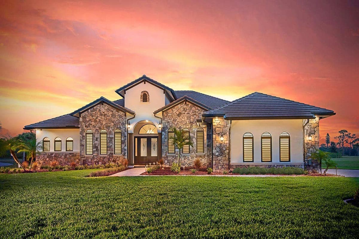 House plan exterior of a two-story home with stone facade, barrel tile roof, arched windows, and a prominent front entry.
