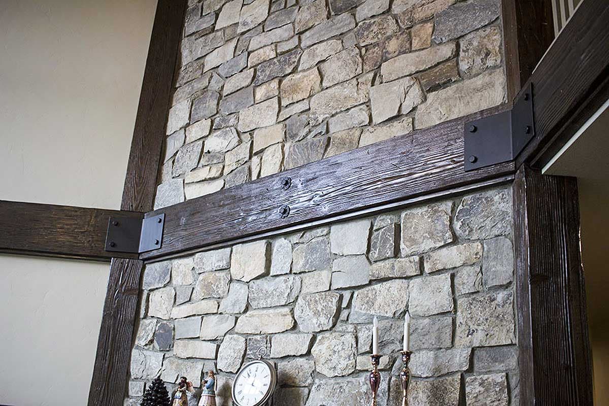 Stone fireplace with dark wood beams and metal brackets.