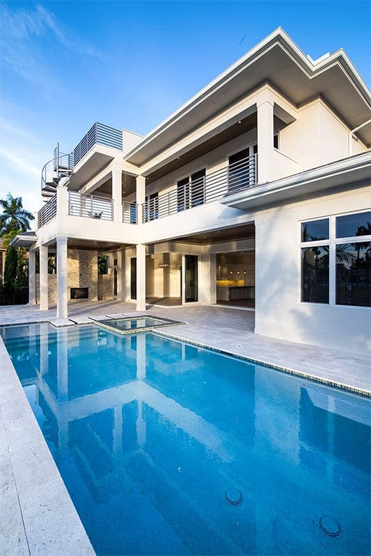 Modern house plan exterior with spiral staircase, multiple balconies, covered patio with fireplace, and swimming pool.