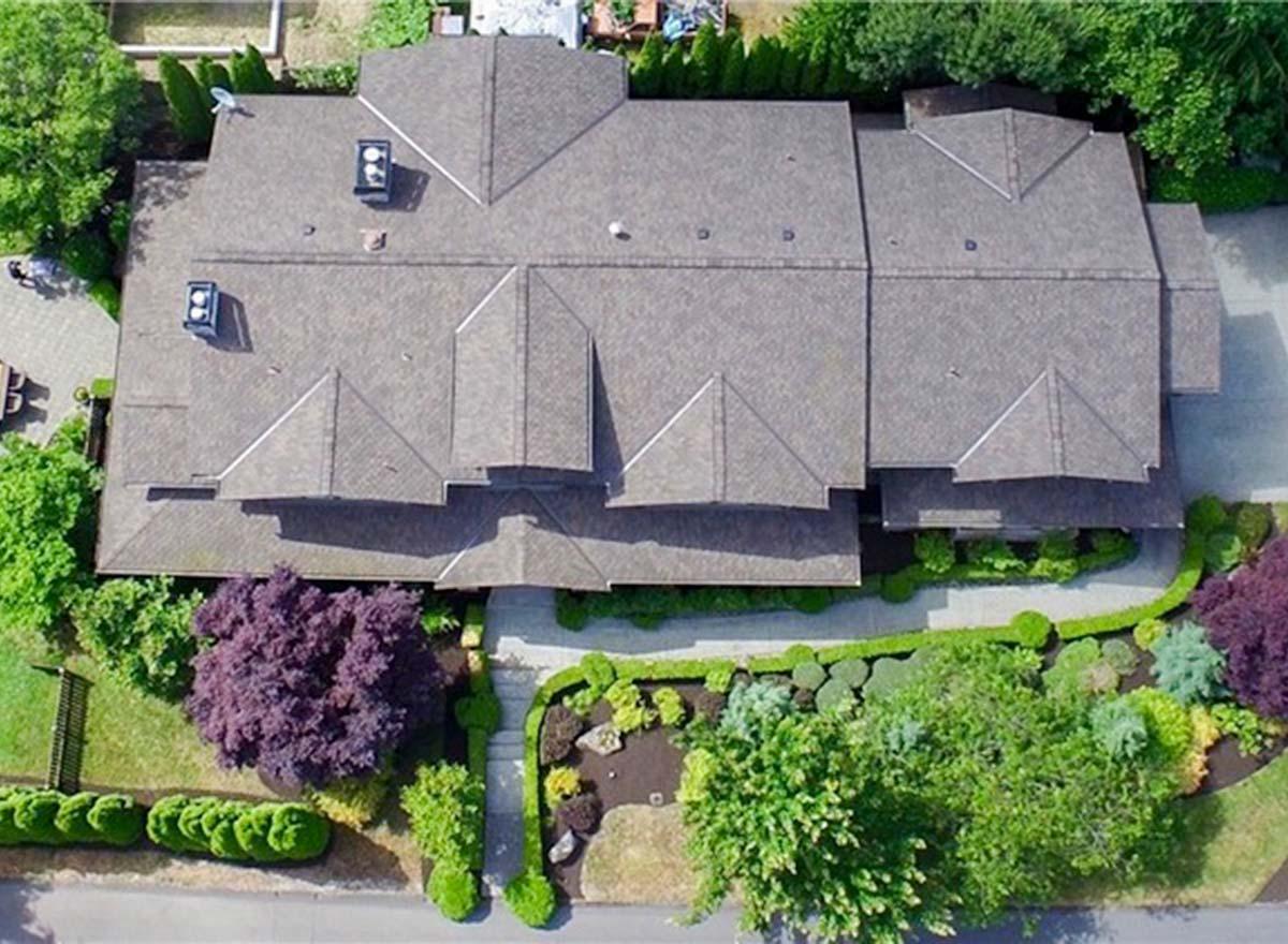 House plan exterior view with a complex roofline featuring multiple gables and two visible chimneys.