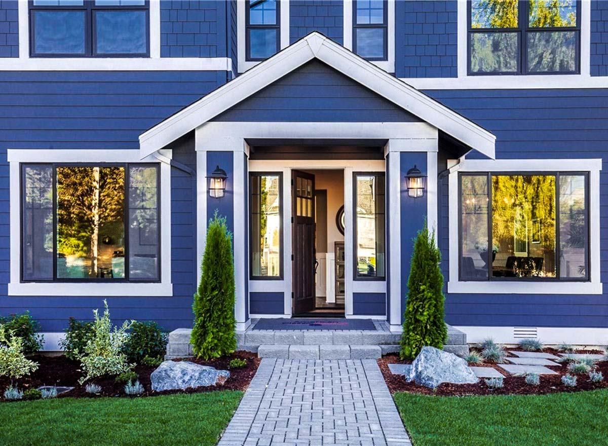 Modern Farmhouse house plan exterior with a gabled portico, dual-pane windows, and blue lap siding.