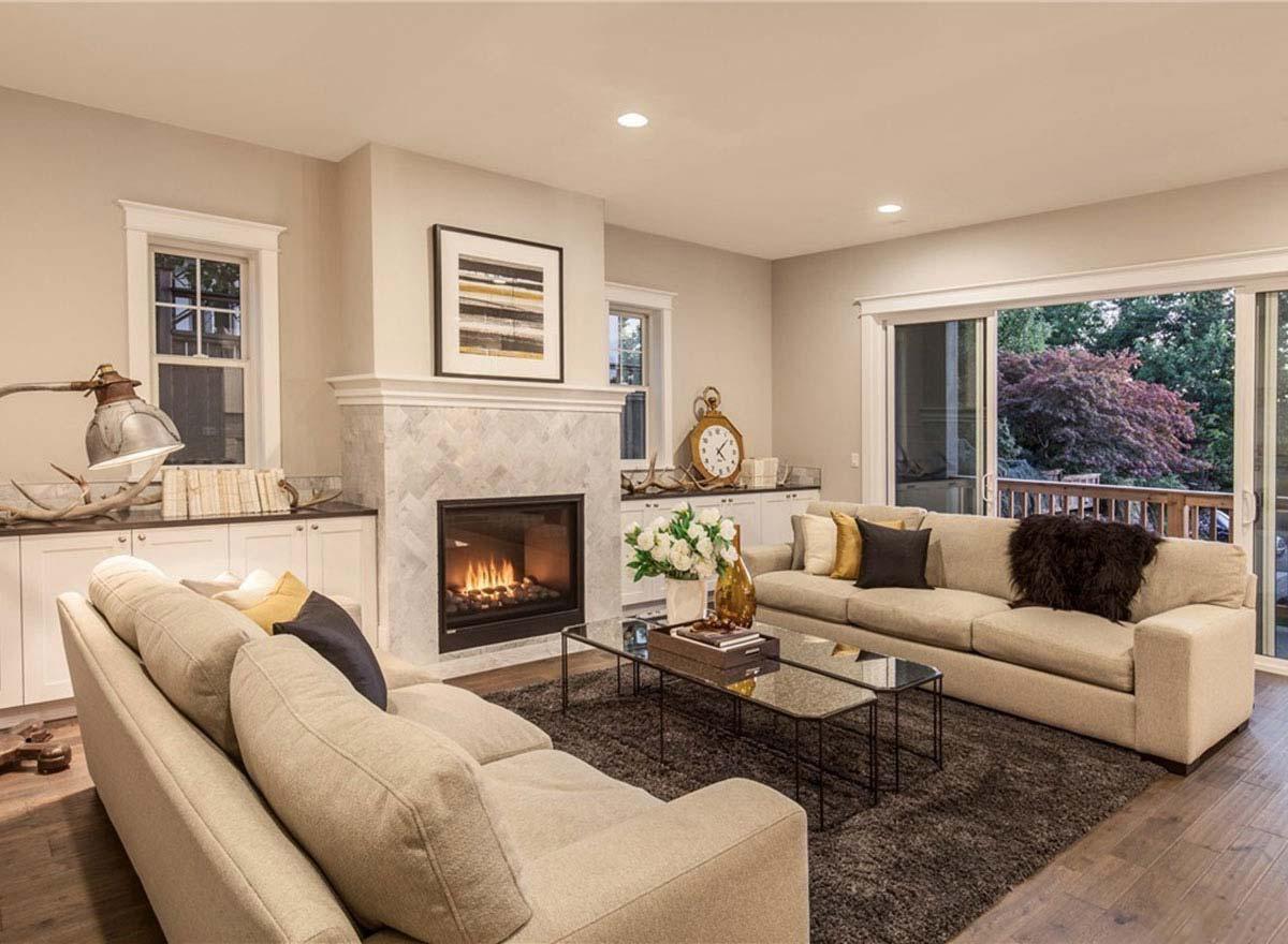 Living room with a fireplace, built-in cabinetry, and sliding glass doors opening to a deck.