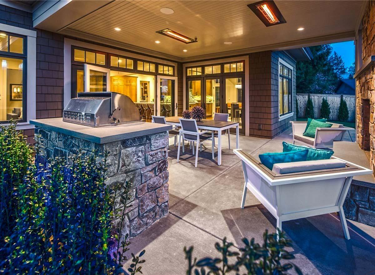 Covered patio with built-in grill, dining set, lounge seating, and access to interior.