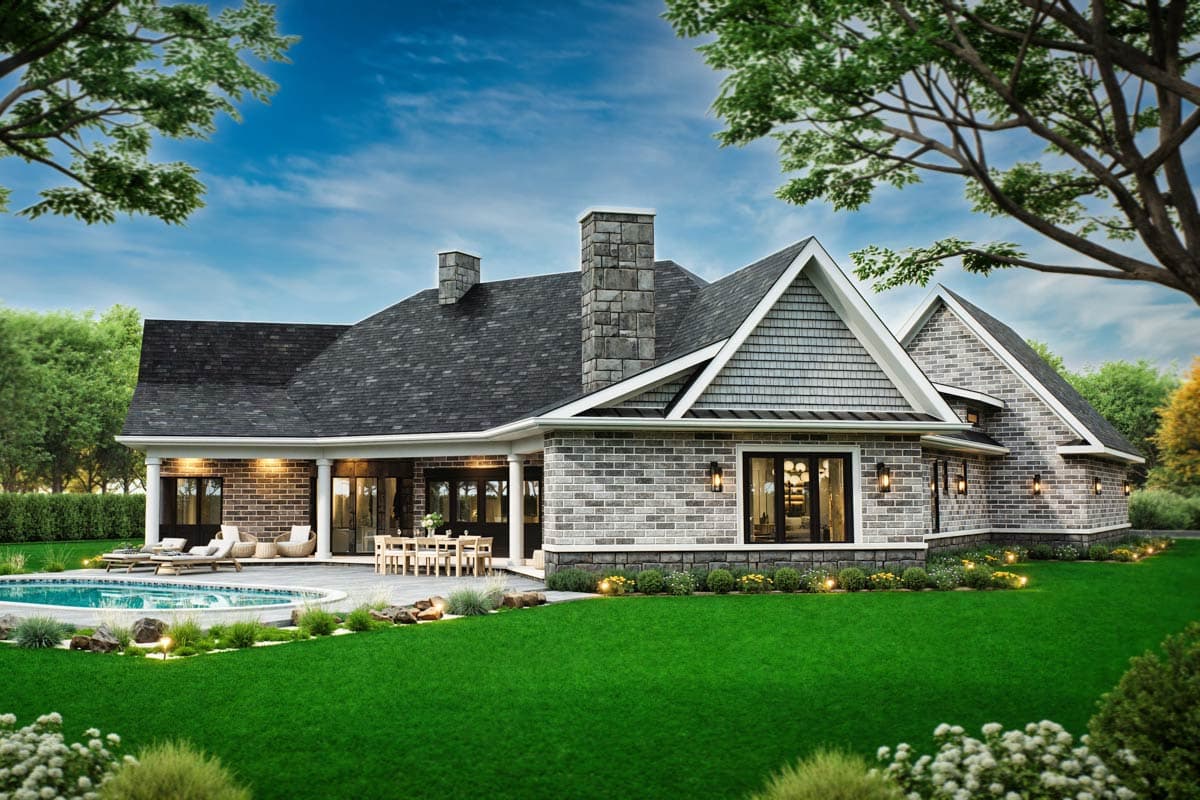 House plan exterior with stone chimney, brick facade, gables with cedar shingles, covered patio, and swimming pool.