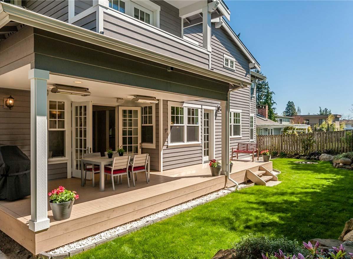 House plan exterior: two-story home with covered deck, double doors, and wide lap siding.