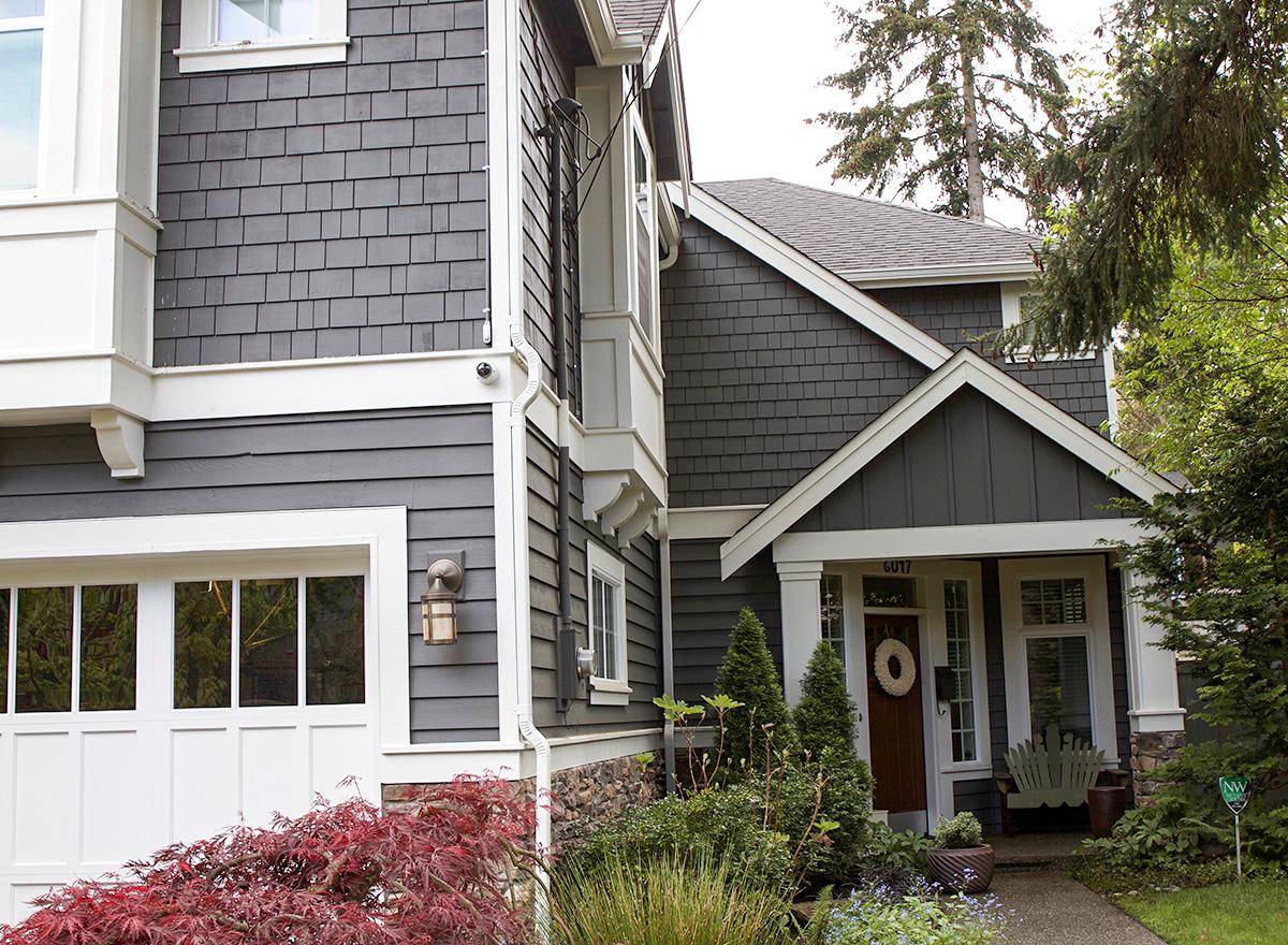 House plan exterior with shingle siding, white trim, attached garage, and covered entry with gable.