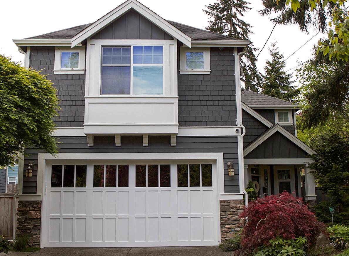 House plan exterior with two stories and a Craftsman style. Features include a prominent garage, multiple gables, and shake siding.