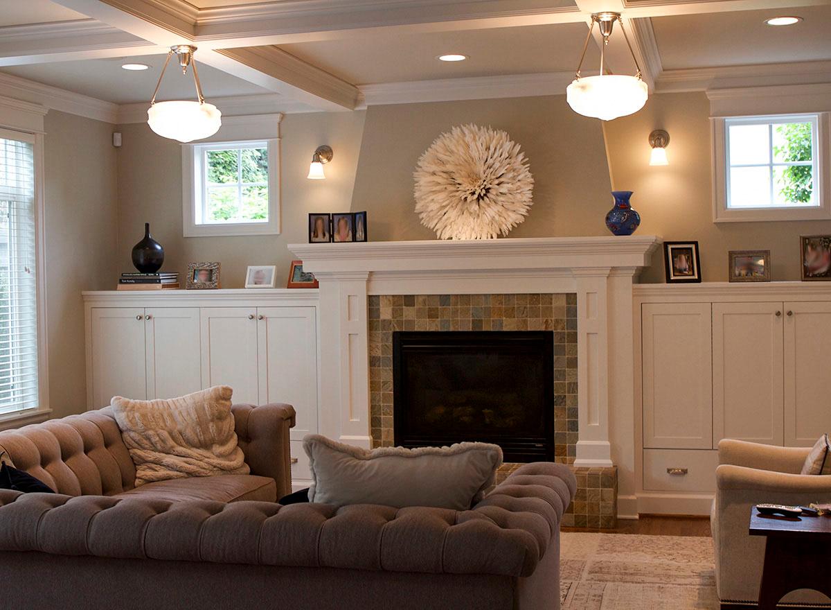 Living room with coffered ceiling, fireplace with tile surround, and built-in cabinets.