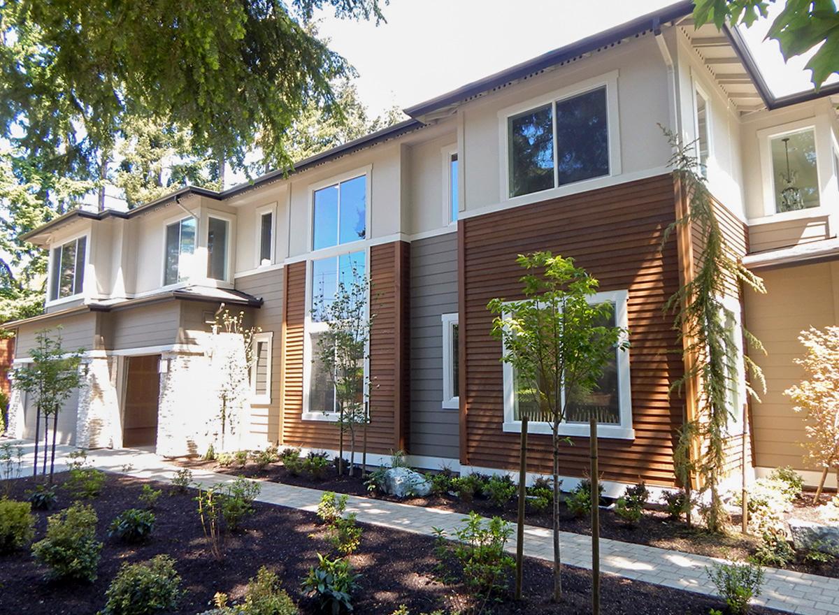 Two-story Modern house plan exterior with horizontal wood siding, stone accents, large windows, and a side-entry garage.