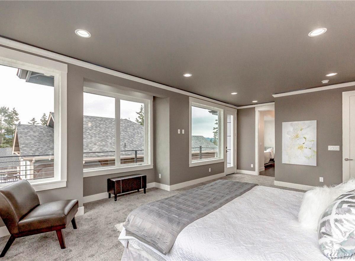 Primary bedroom with large windows, sitting area, and access to an adjoining room.