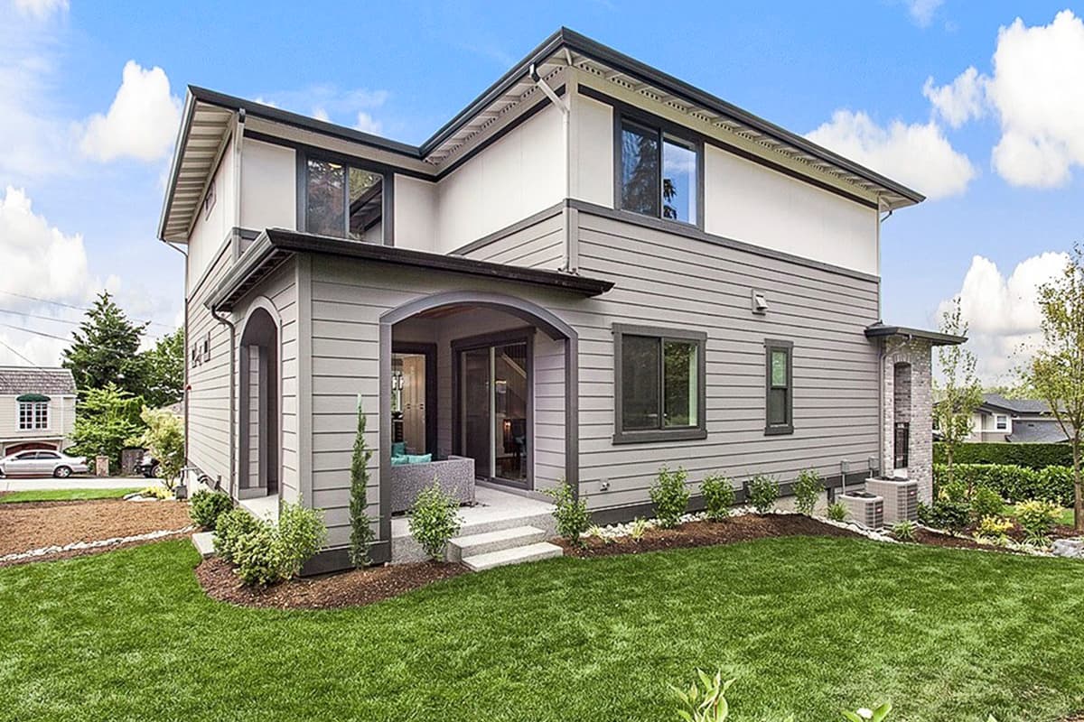 House plan exterior: two-story modern home with arched entry, horizontal siding, and layered rooflines.