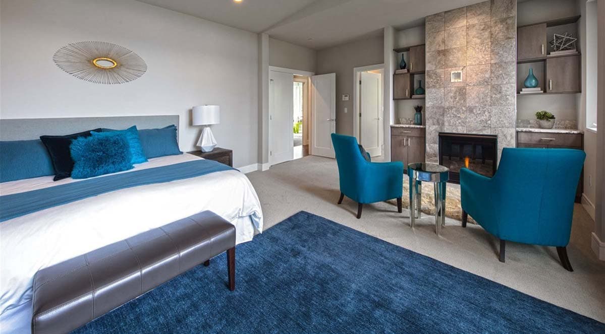 Spacious bedroom with king bed, fireplace, built-in cabinets, and seating area.