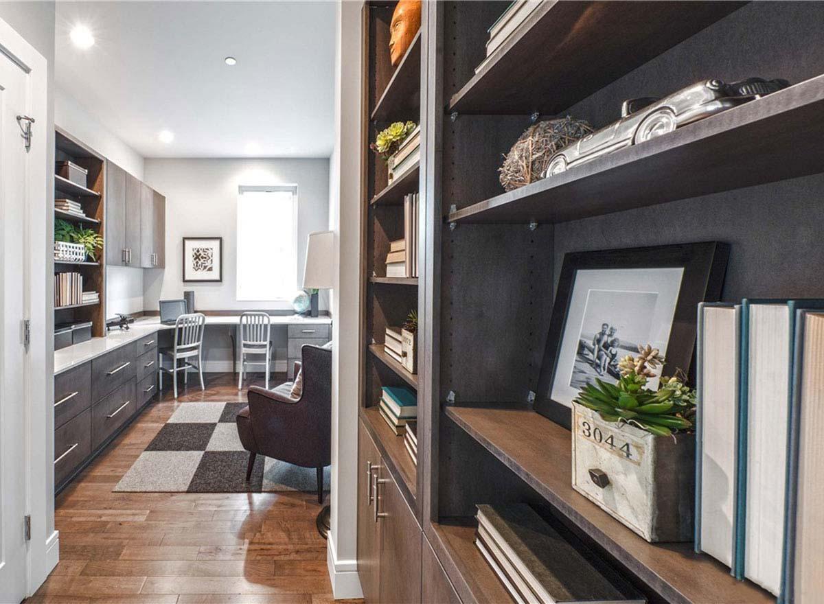 Home office with built-in desk, shelving, chair, and desk area with two workstations.