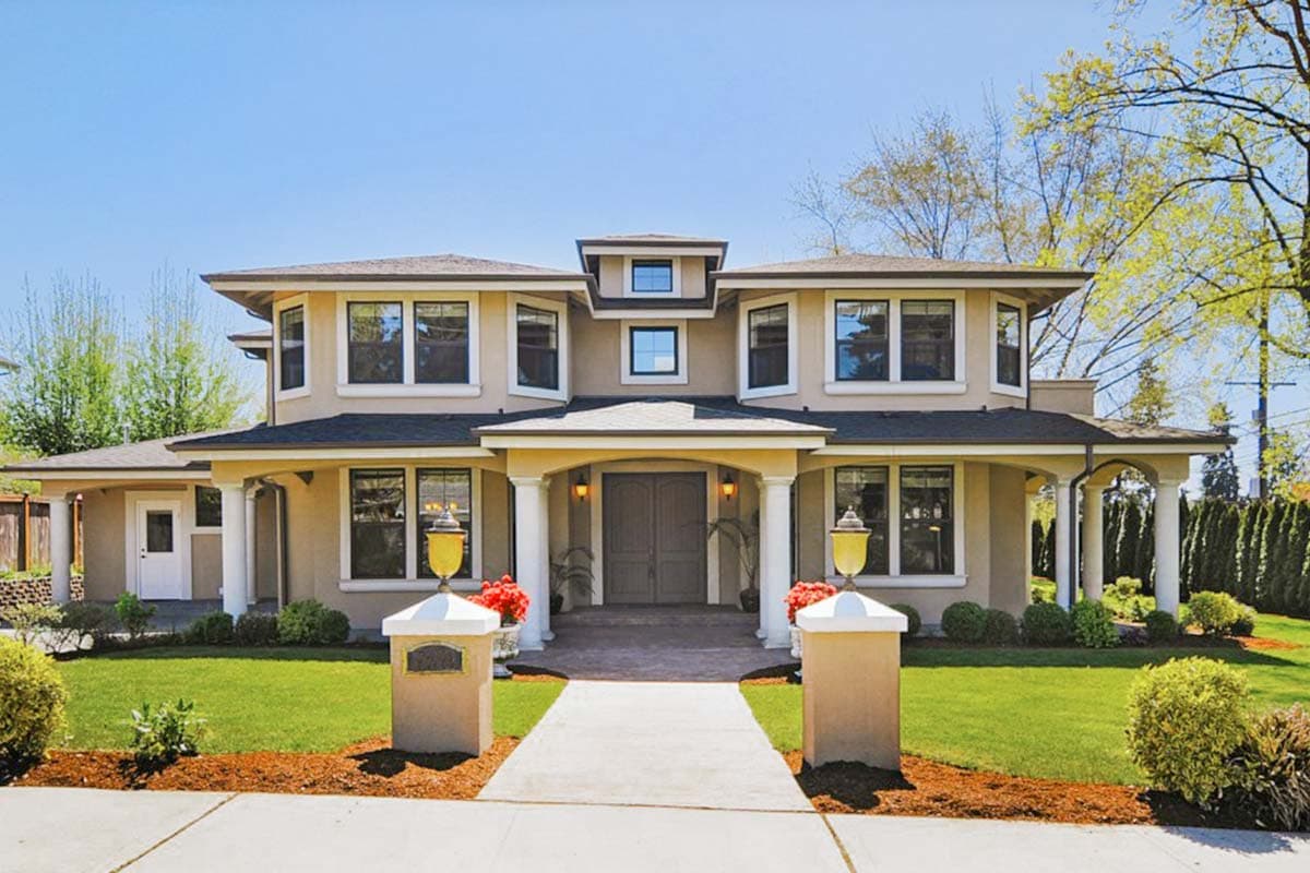 Two-story house plan exterior with a covered entry, multiple bay windows, and a hip roofline.