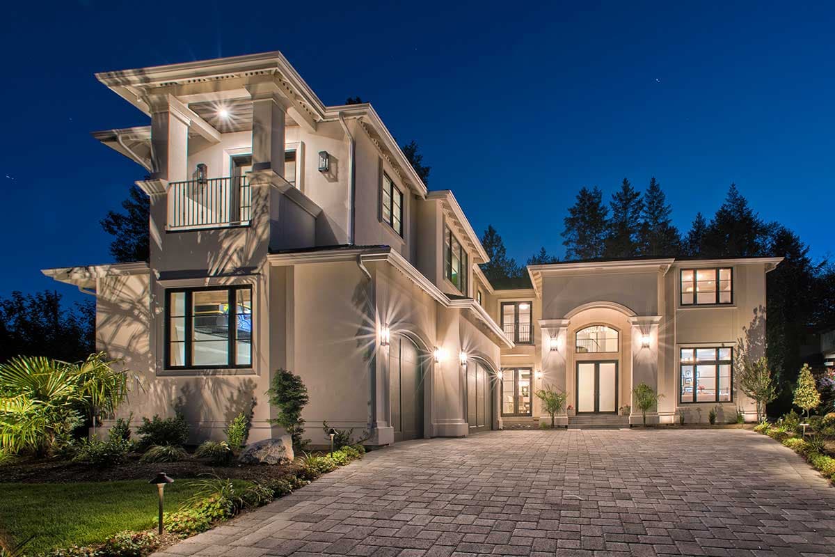 House plan exterior with two stories and a stucco facade. Features include a covered balcony, arched entryway, and multiple garage bays.