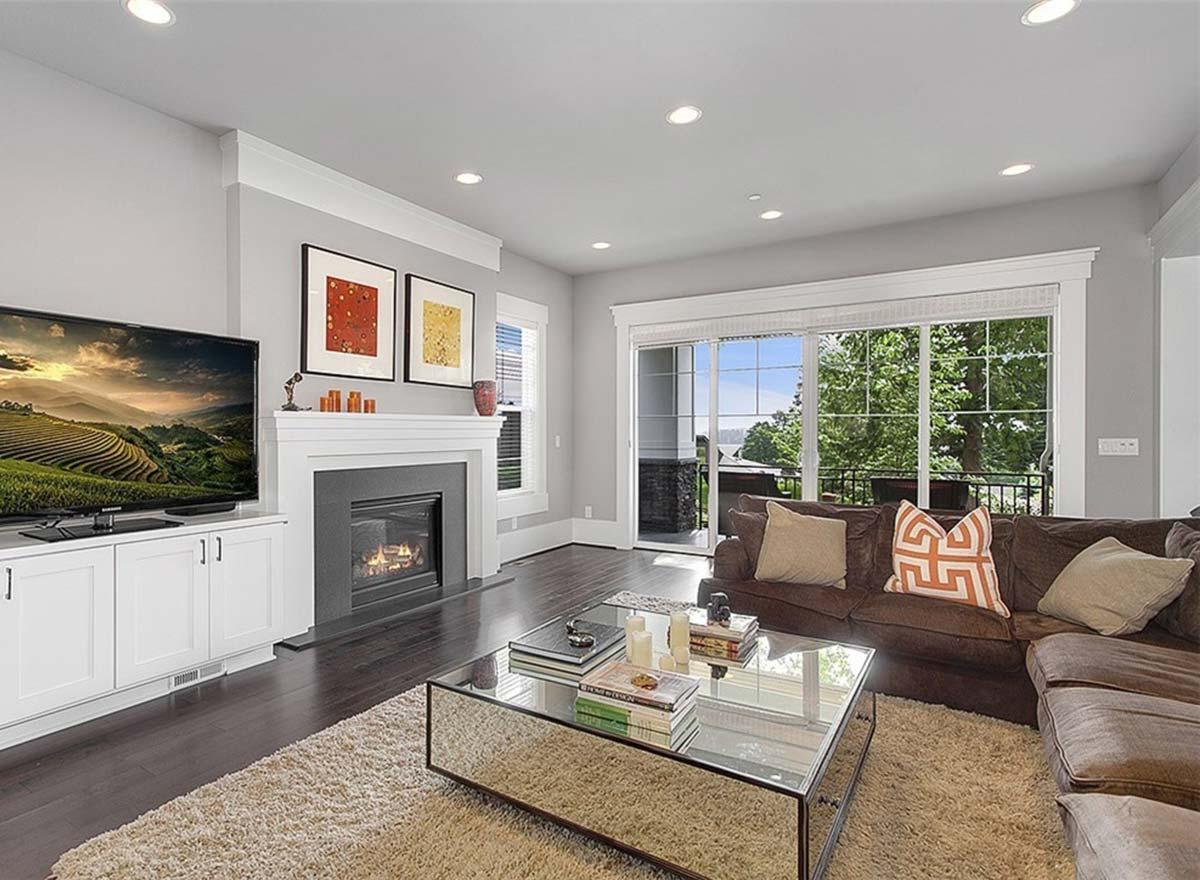 Living room interior with fireplace, television, sofa, and sliding glass doors opening to a patio with a view.