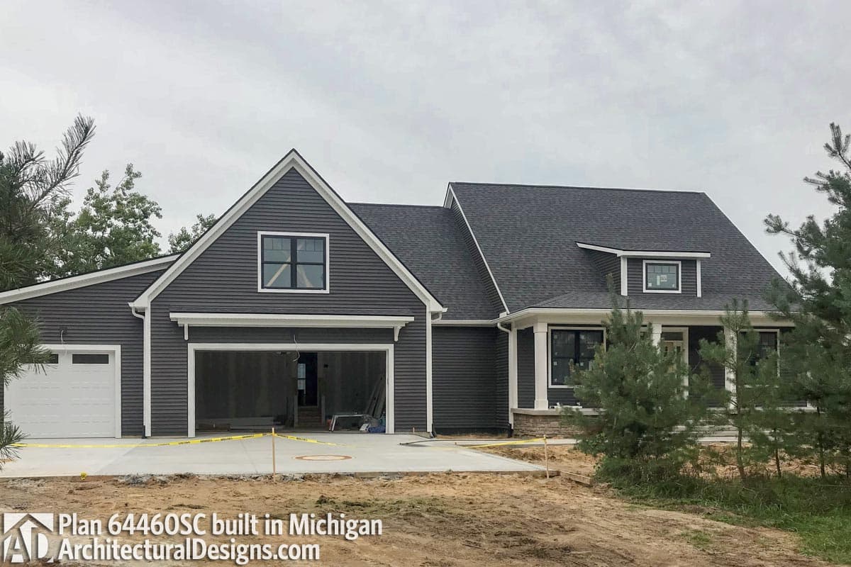 House plan exterior with a two-car garage, gable, and front porch with columns. Dark siding and asphalt roof.