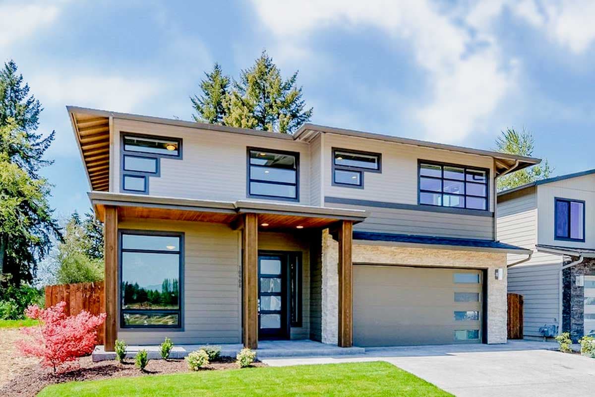 Modern two-story house plan exterior with a covered entry, large windows, natural wood accents, stone veneer, and a two-car garage.