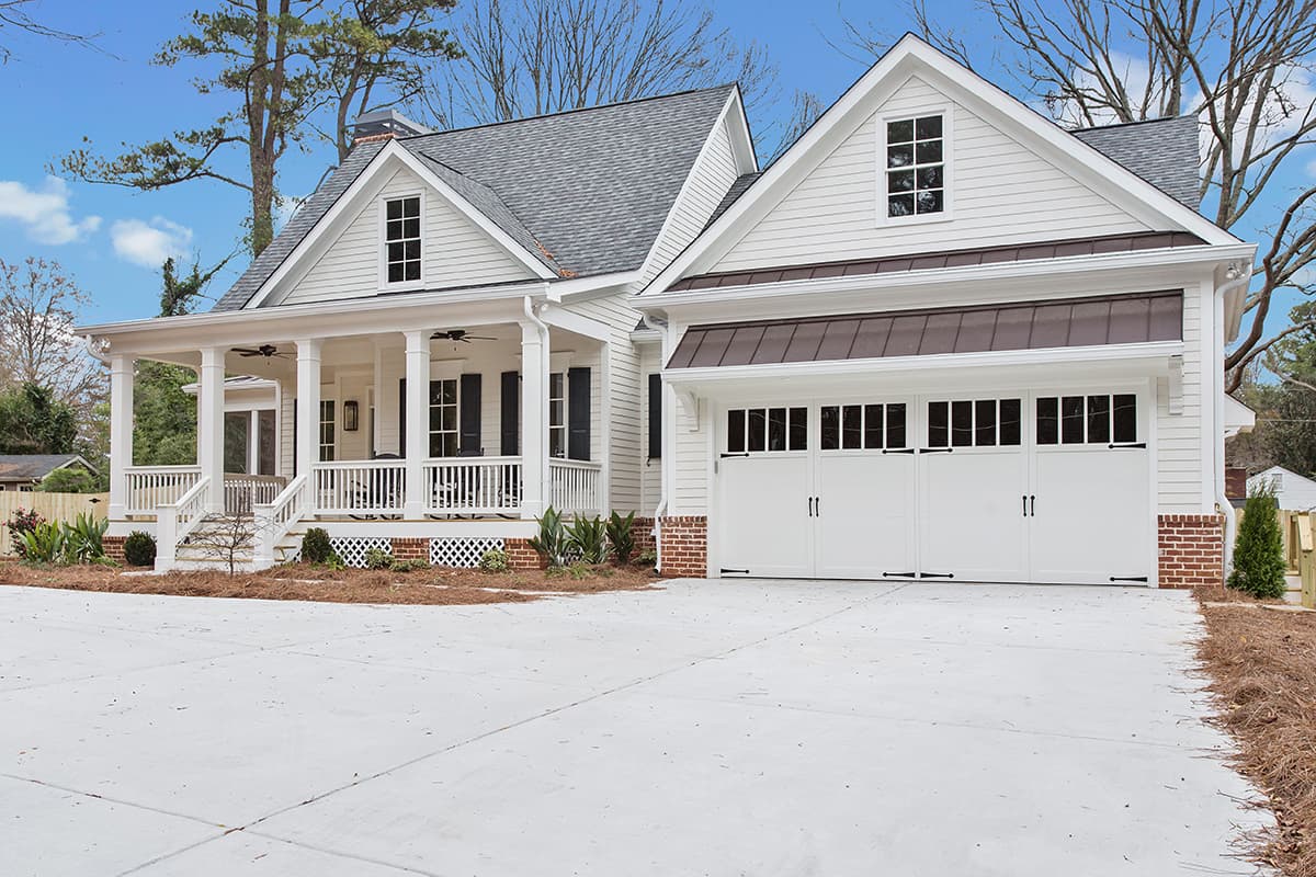House plan exterior: two-story Modern Farmhouse with wrap-around porch, dormer windows, and a metal-roofed garage.
