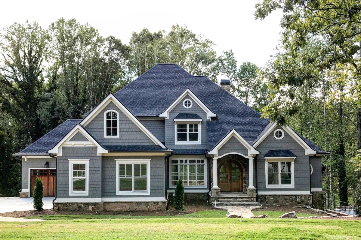 House plan exterior: Two-story Modern Farmhouse with gables, dormers, arched entry, and attached garage.