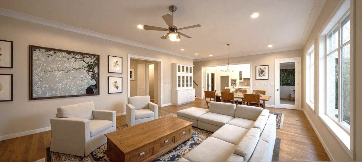 Open concept living space with sectional sofa, dining area, and a large bay window.