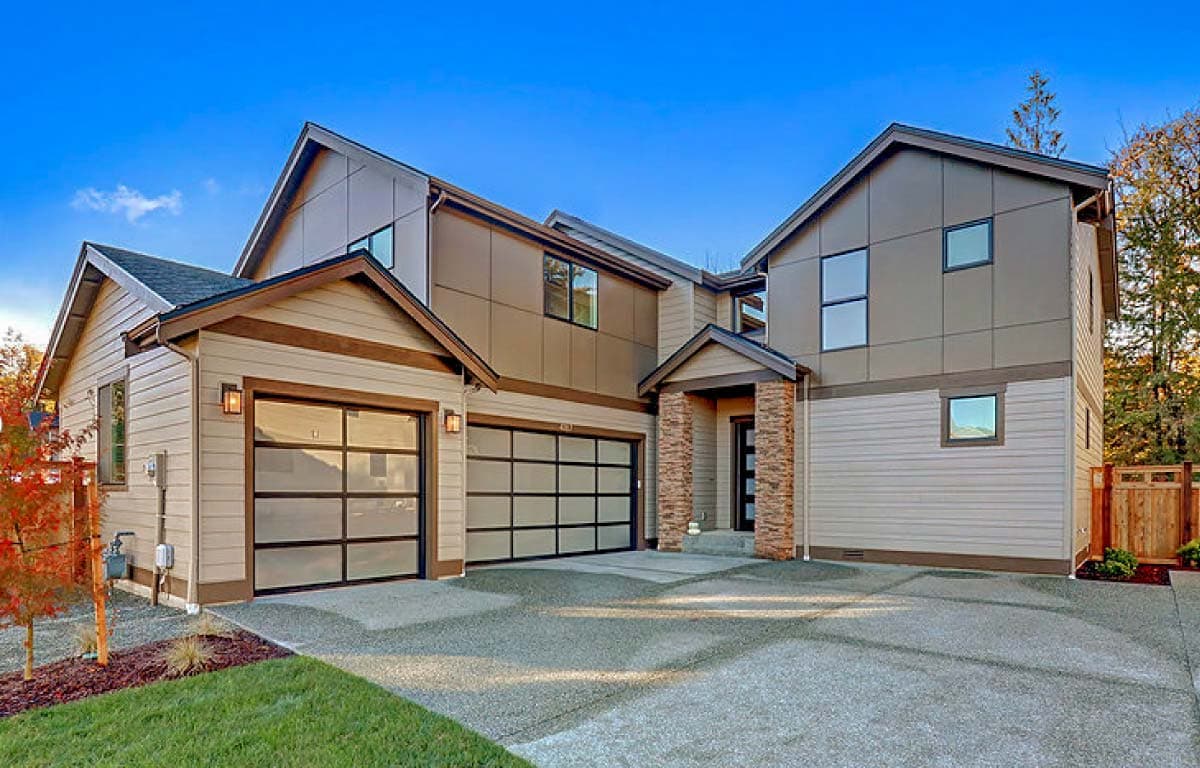 House plan exterior. Two-story Modern house with a combination of board and panel siding, two-car garage, and gabled rooflines.