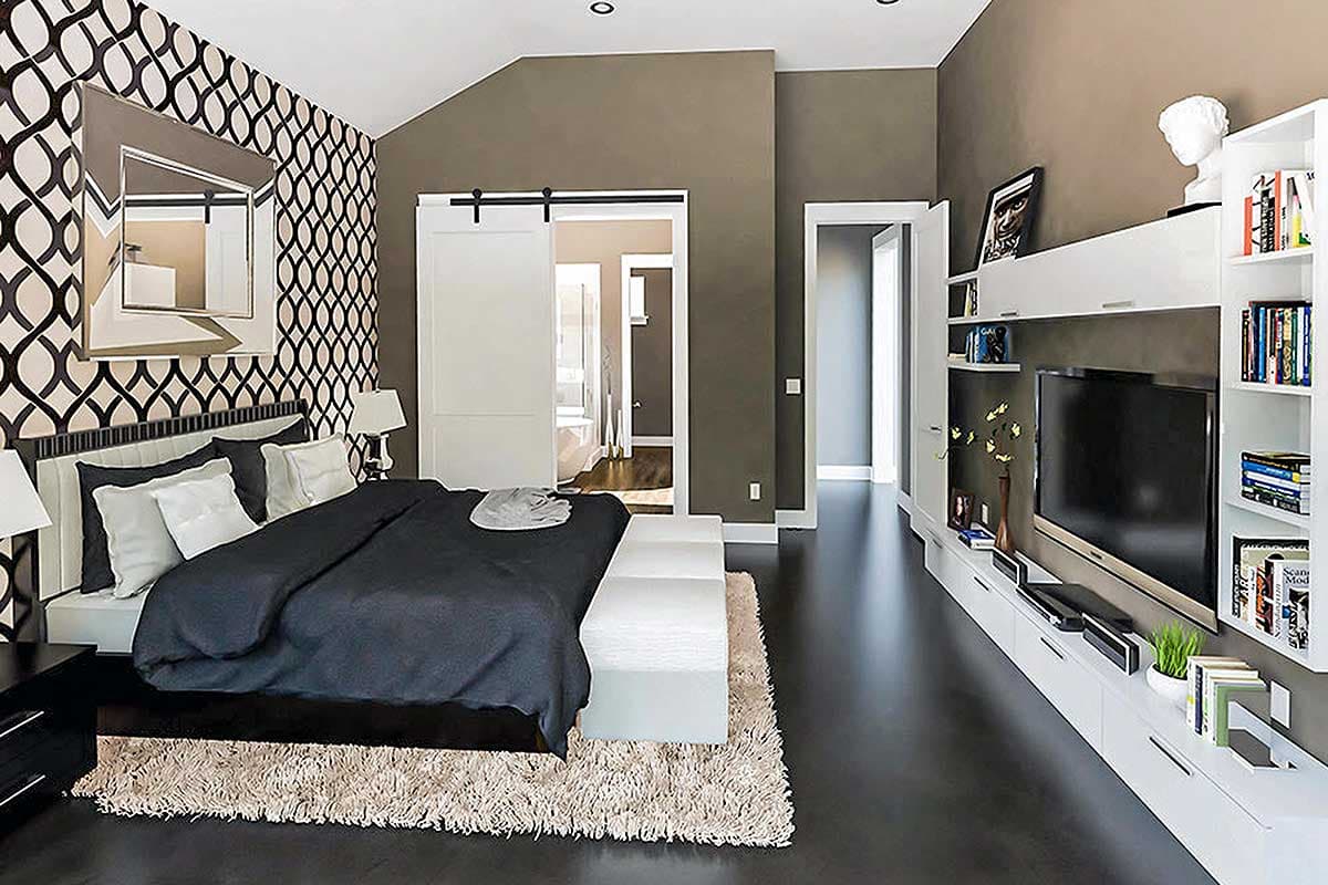 Interior view of bedroom with patterned wallpaper, vaulted ceiling, barn door, and wall-mounted media console.