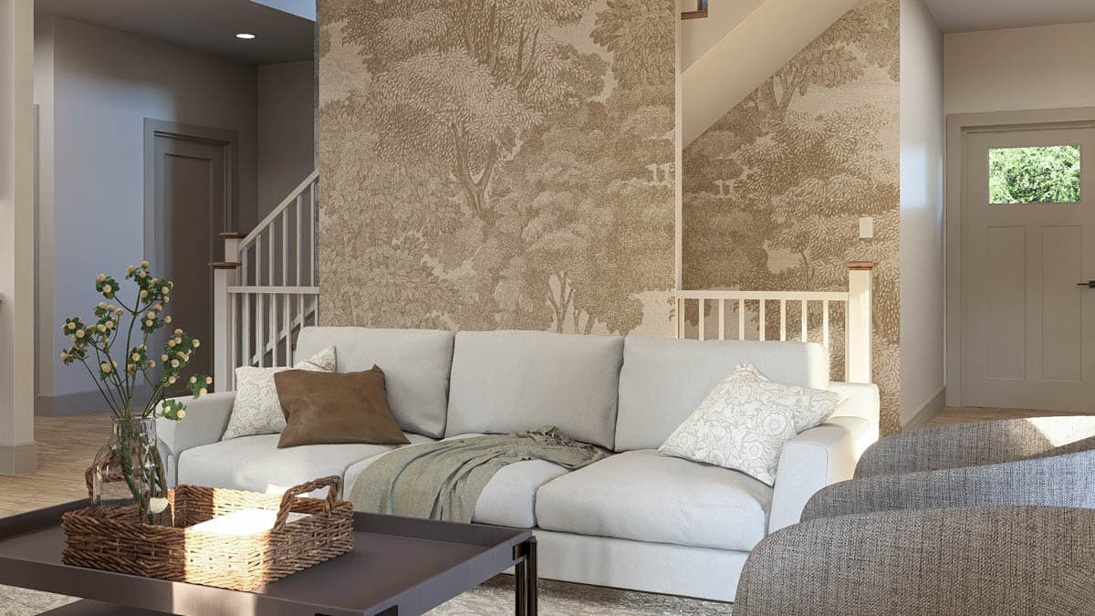 Interior view of a living area featuring a sectional sofa, stairs with banister, and botanical wallpaper.