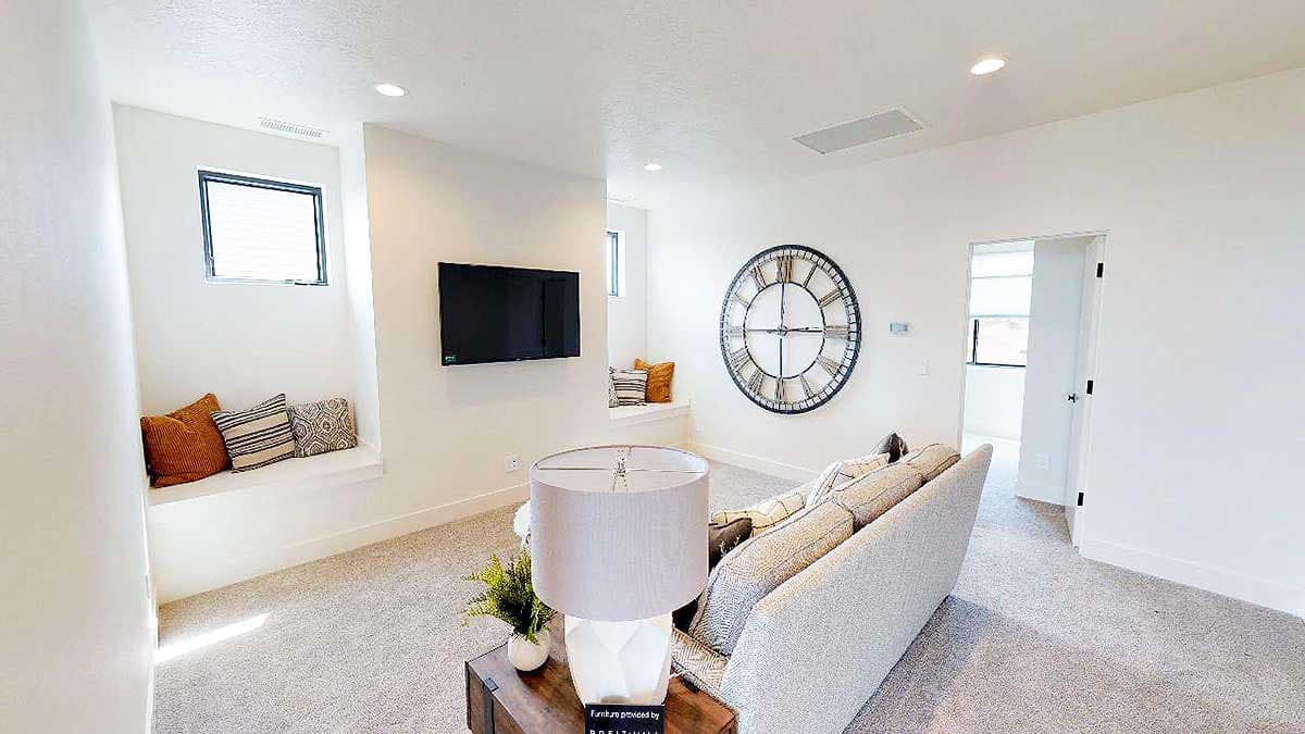 Interior rendering of a living area with a window seat, television, and large wall clock.