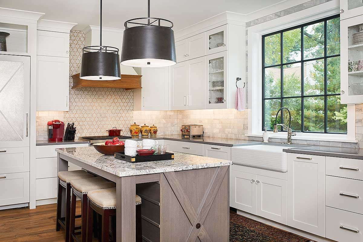 Kitchen featuring a central island, farmhouse sink, and large multi-pane window with dark framing.