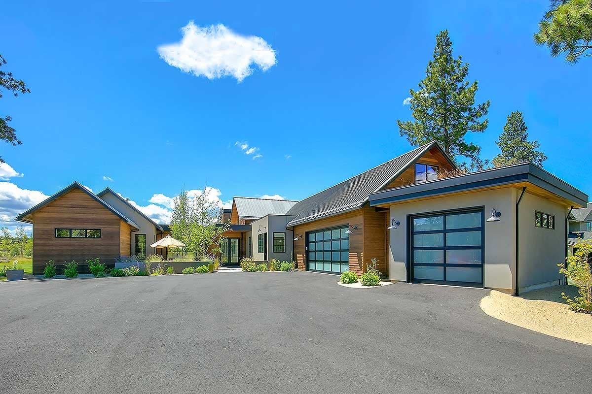 House plan exterior with modern style, multiple gabled roofs, a detached garage with glass door, and wood siding.