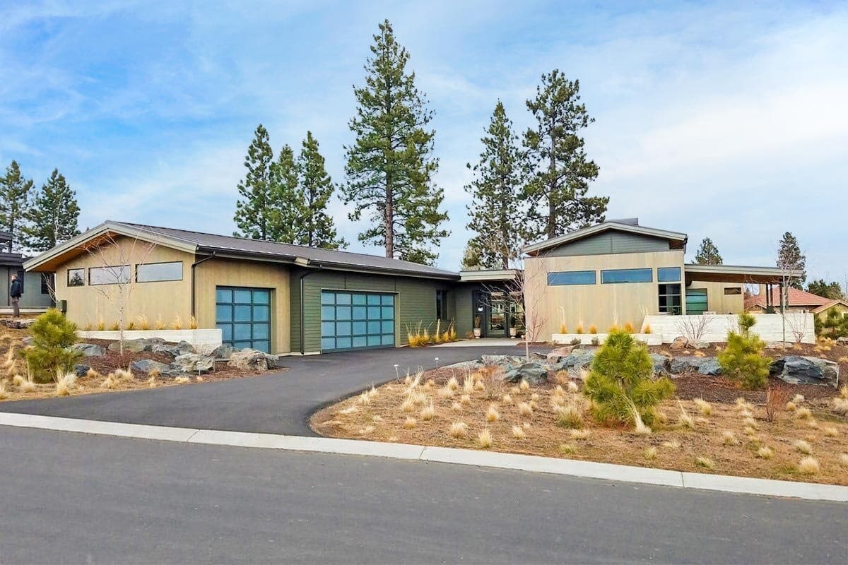 House plan exterior with modern design. Features include low-slope rooflines, clerestory windows, and glass garage doors. Single-story design.