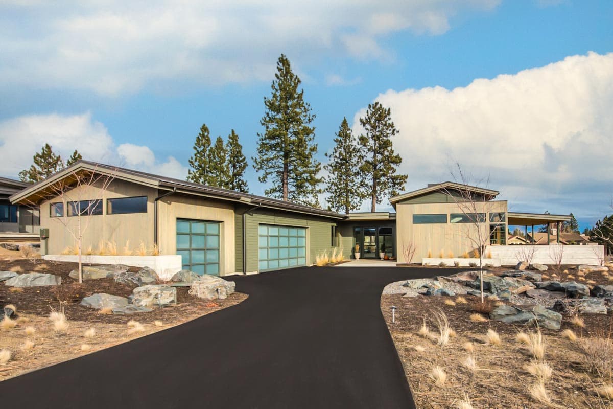 Modern house plan exterior with angled rooflines, horizontal windows, and two glass panel garage doors.