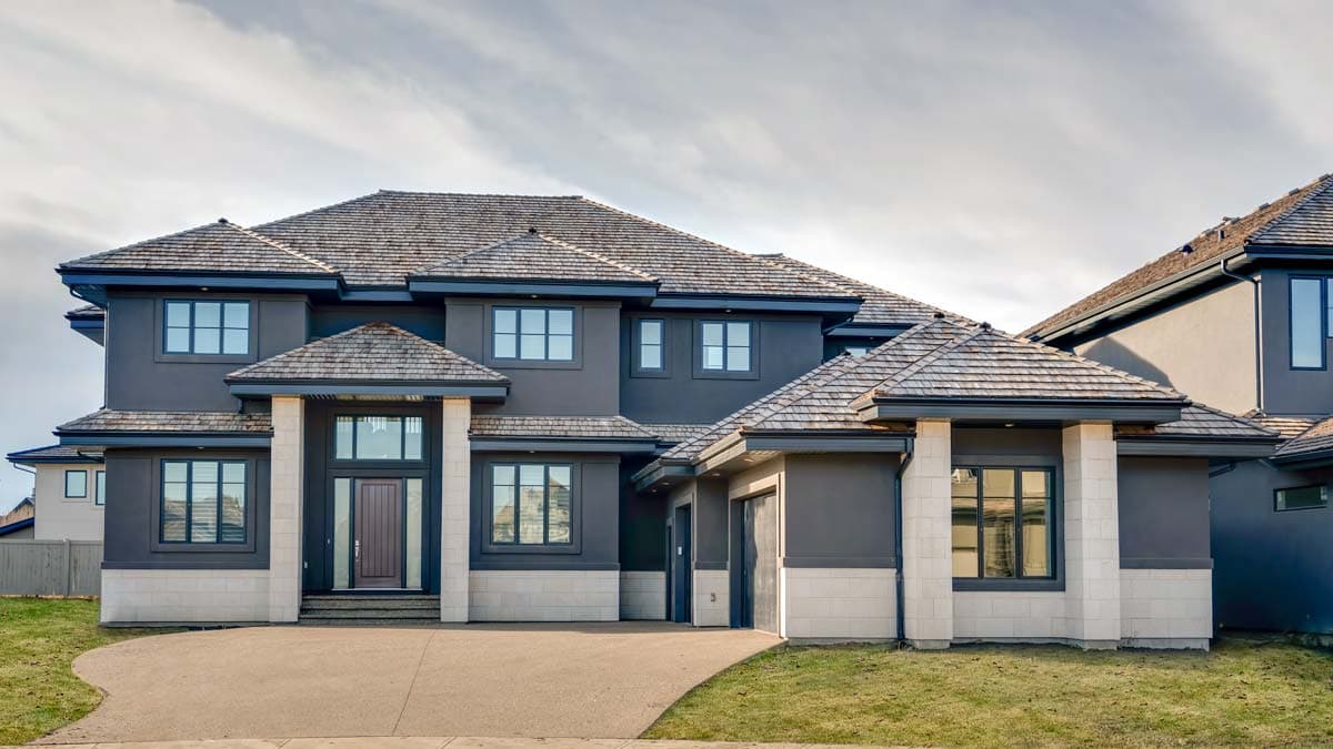 House plan exterior: Two-story Modern home with a gabled roof, stone accents, prominent entry with double columns, and attached garage.