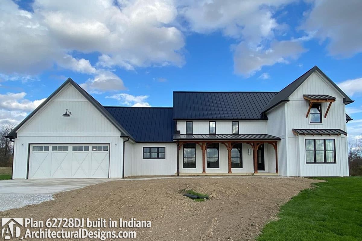 House plan exterior: Modern farmhouse with white board-and-batten siding, dark metal roof, covered porch with timber posts, and attached garage.