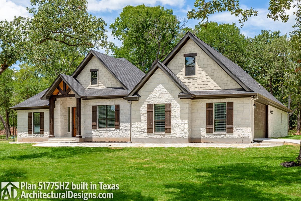 House plan exterior: One-story Modern Farmhouse with stone and shake siding, covered entry with timber accents, gables, and attached garage.