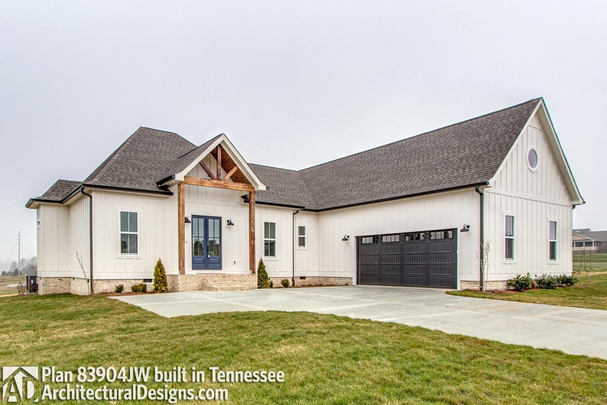 Modern Farmhouse house plan exterior with board-and-batten siding, gable roof, exposed rafter tails, and attached three-car garage.