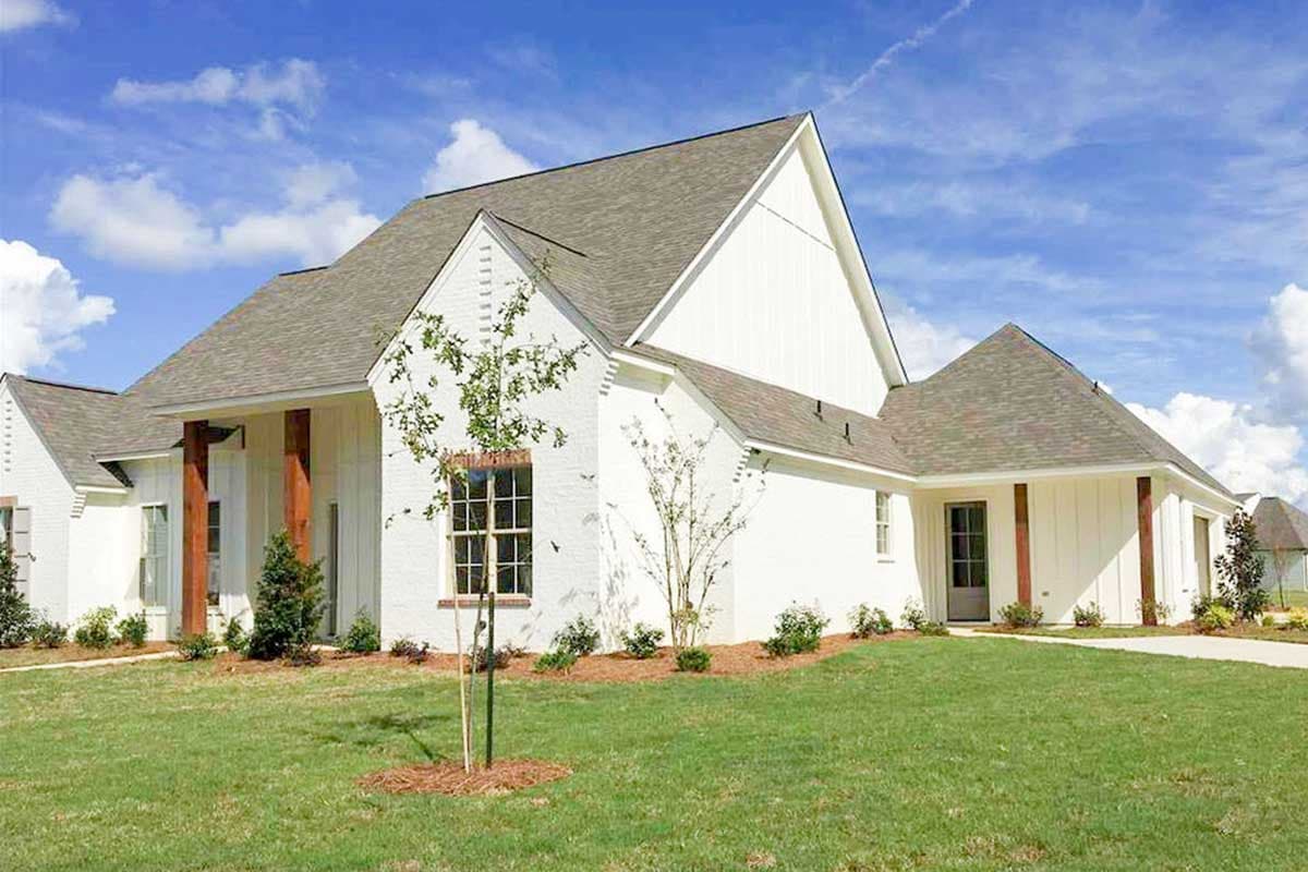 House plan exterior: Modern Farmhouse style, one story, white brick, gables, board and batten siding, wood beams, covered entryway.