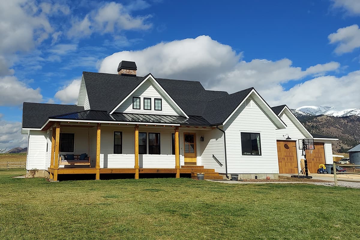 House plan exterior: Two-story Modern Farmhouse with a gabled roof, a covered porch, dormers, and an attached garage.