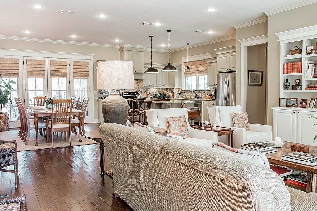Open concept living area with dining room, kitchen with island, and seating area with fireplace and built-in shelves.