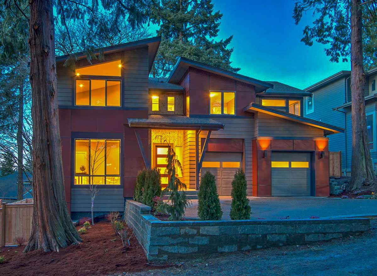 Modern house plan exterior with asymmetric rooflines, large windows, covered entry, and a two-car garage.