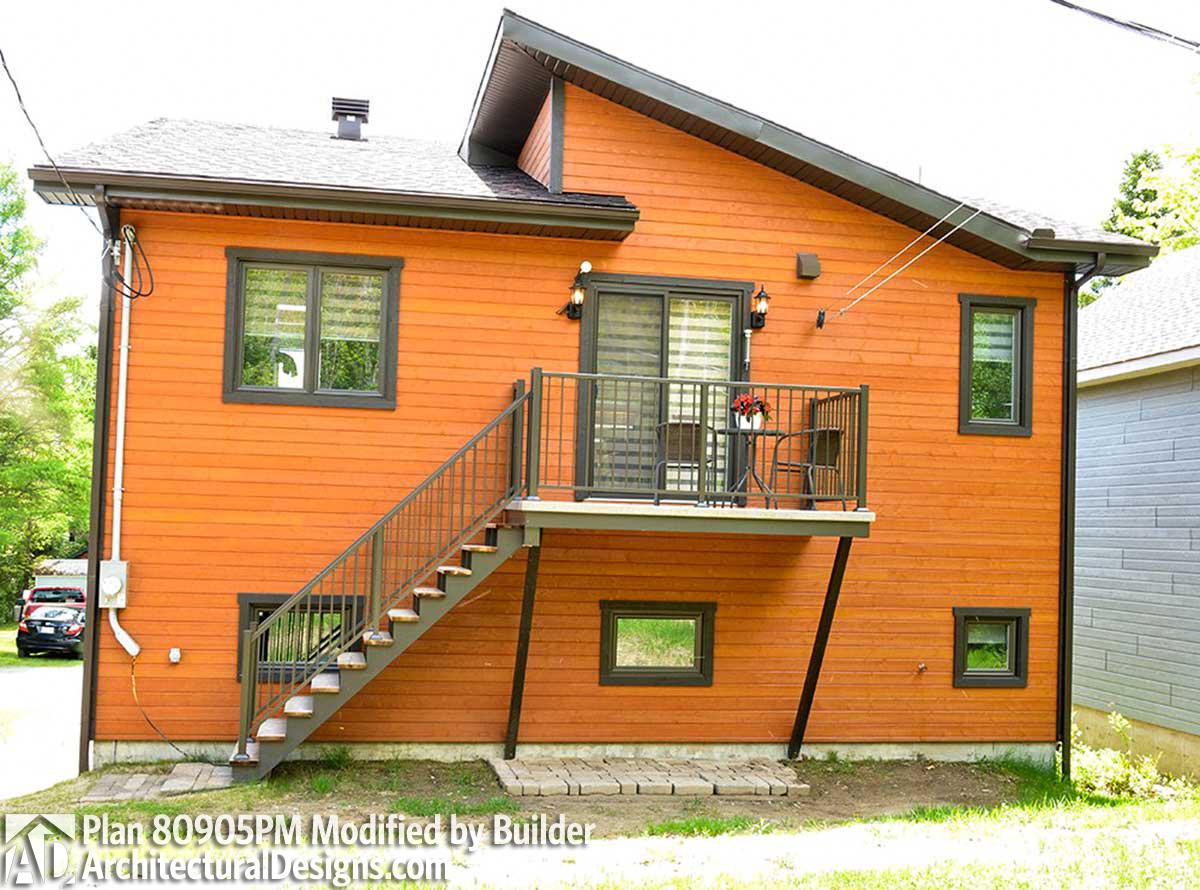 House plan exterior with orange horizontal siding, a raised deck, metal railings, and an external staircase.