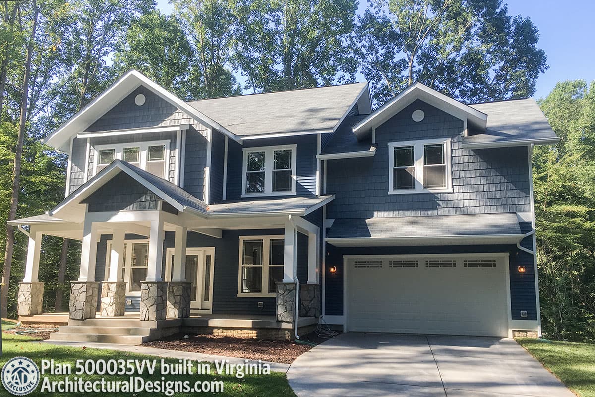 House plan exterior: two-story dwelling with gabled dormers, stone-clad porch columns, and a two-car garage.