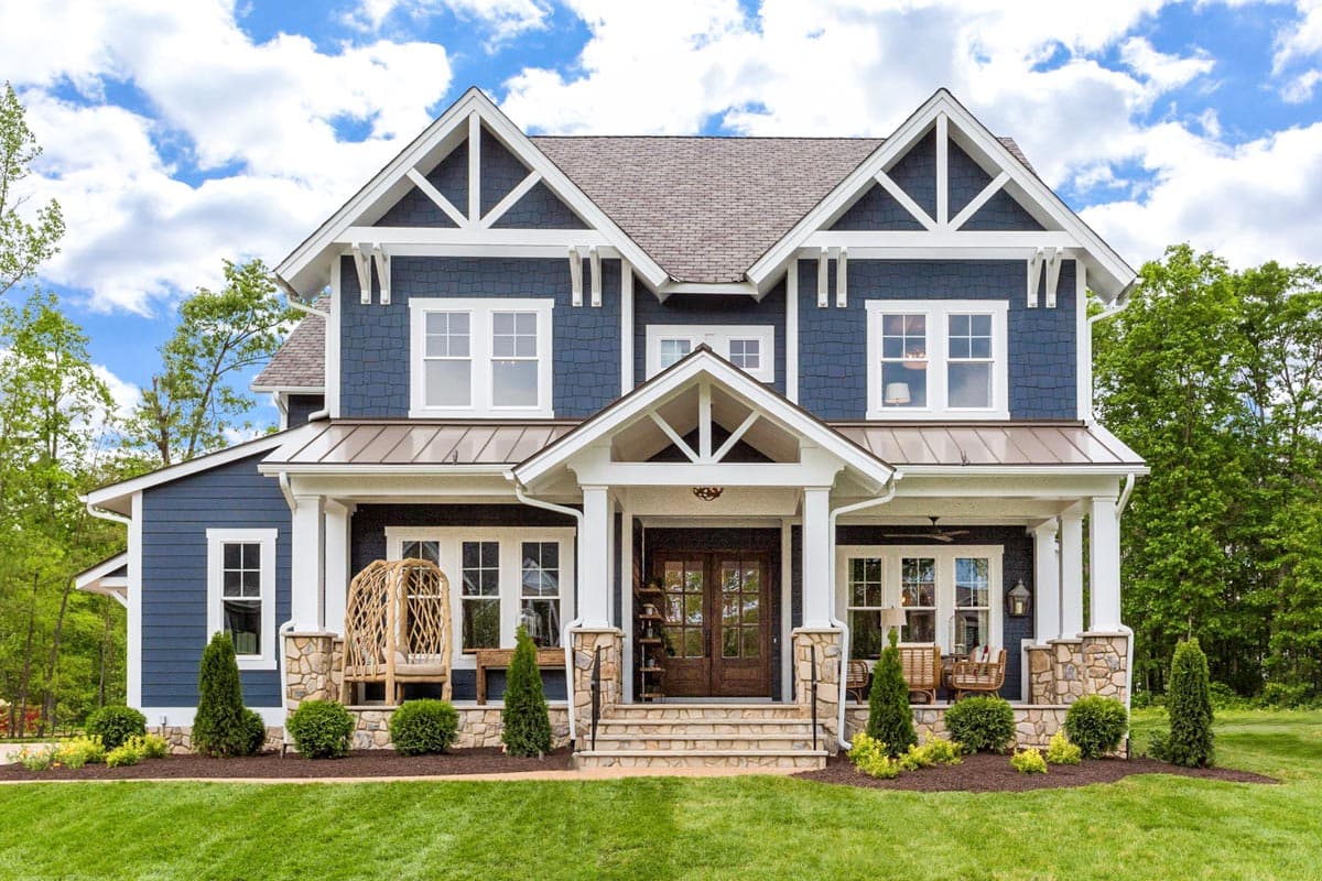 House plan exterior. Two-story Craftsman home with gabled roof, prominent front porch, and exposed rafter tails.