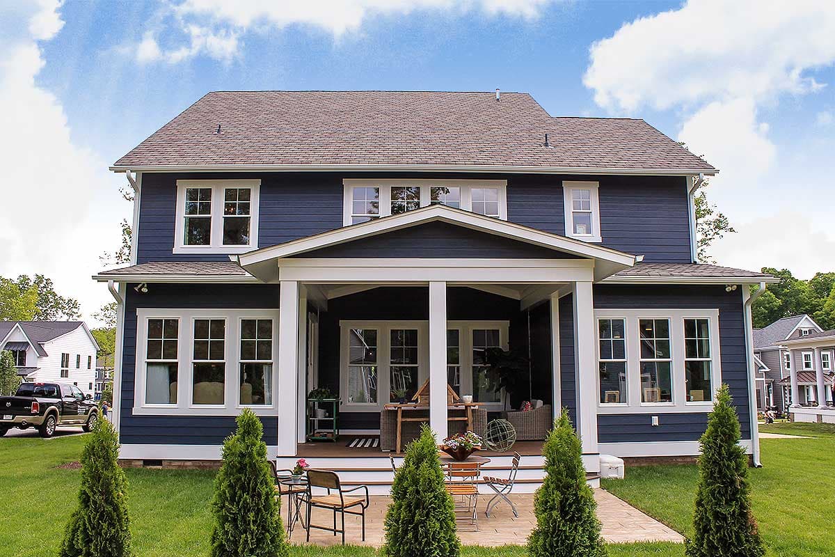 Two-story house plan exterior with a covered front porch, gables, and multiple windows.