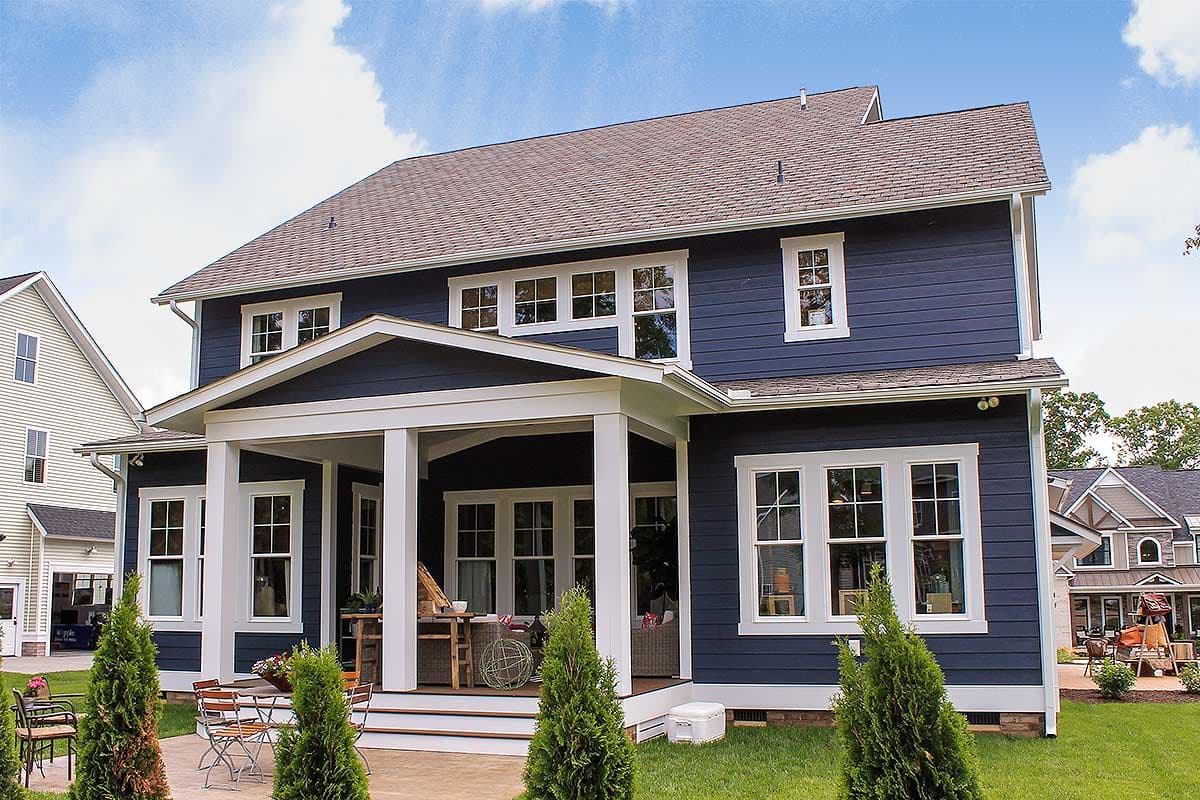 Two-story Modern Farmhouse exterior with covered front porch supported by square columns, multi-pane windows, and blue horizontal siding.