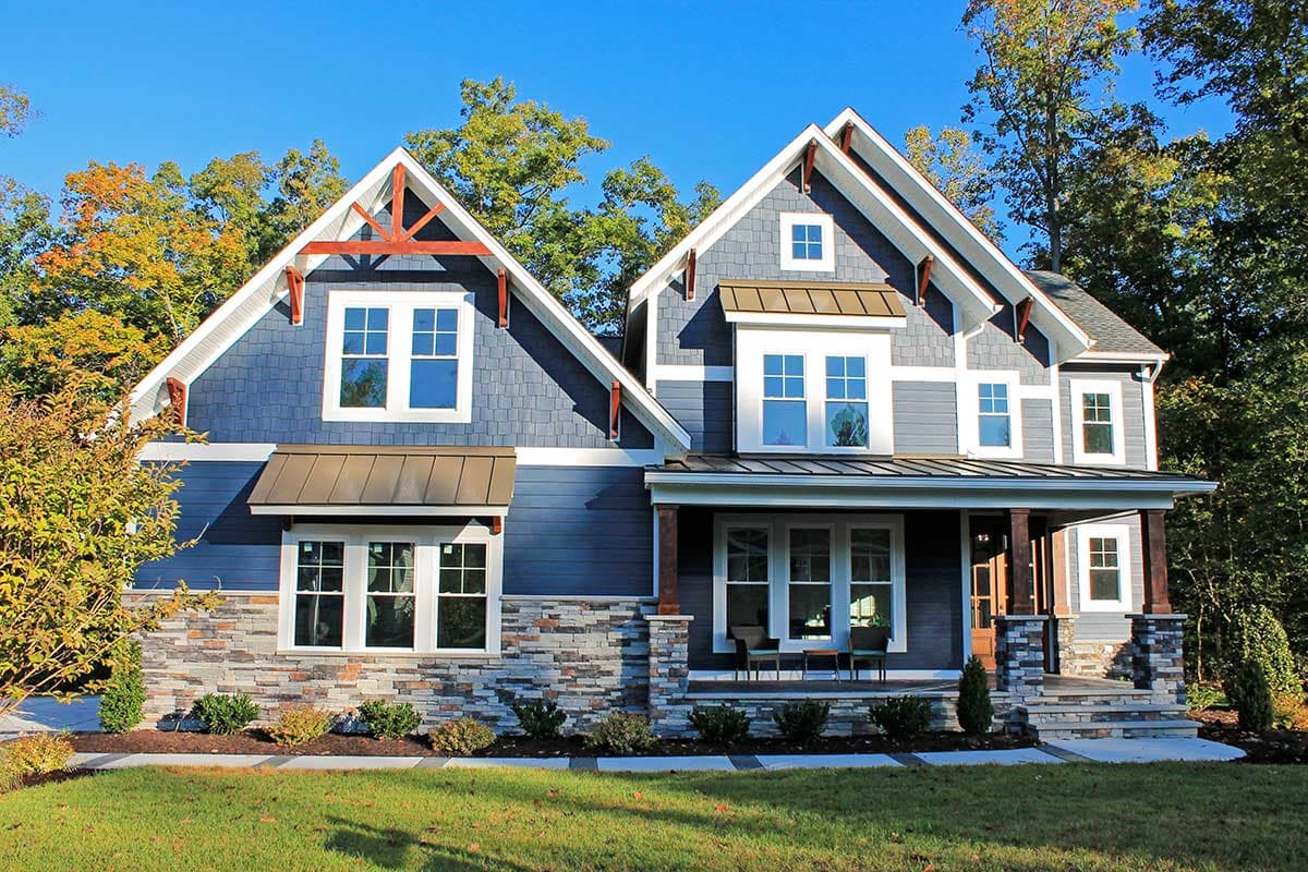 House plan exterior. Two-story Craftsman home with gabled rooflines, stone veneer, front porch with columns, and a dormer.